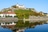 Festung auf Hügel mit Spiegelung im Fluss.