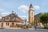 Historische Gebäude und Kirchturm auf Stadtplatz bei sonnigem Wetter.