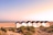 Strandhütten am Meer mit Sand und Dünen im Vordergrund.