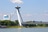 Brücke mit Aussichtsturm über Fluss unter blauem Himmel.