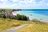 Pfad führt zu Küste mit Klippen, Dorf und Meer.