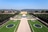 Schlosspark mit symmetrischen Gartenanlagen und Schloss im Hintergrund.