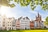 Bunte Häuserreihe und Kirche am sonnigen Tag.