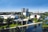 Moderne Gebäude und Landschaft bei Sonnenschein, mit Wasserflächen.
