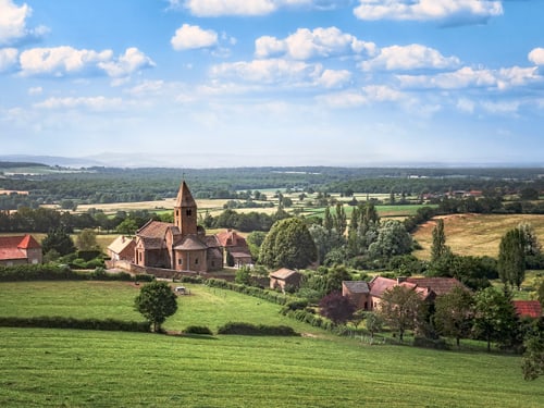Ländliche Landschaft mit Kirche und Feldern.