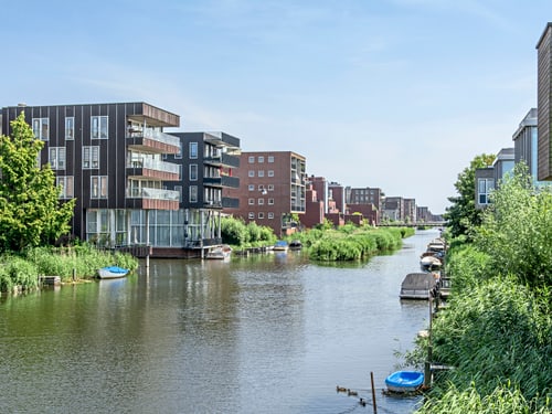 Wasserkanal zwischen modernen Wohngebäuden mit Booten.