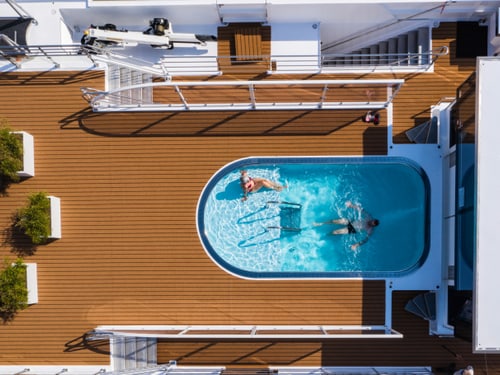 Vogelperspektive auf das ovale Schwimmbecken der Excellence Empress mit zwei Personen im Wasser.