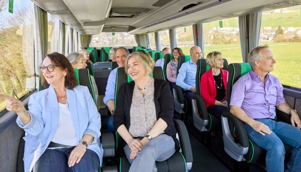 festspielsommer-auf-dem-rhein-2.jpg Gruppe von Menschen in einem Bus lächeln und geniessen die Fahrt.