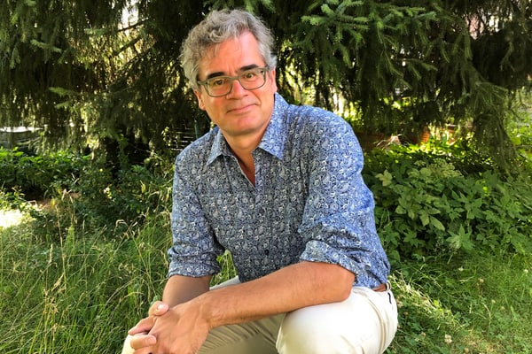 urs-heinz-aerni-fachbegleitung-der-reise.jpg Mann in gemustertem Hemd sitzt im Garten.