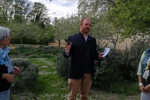 paris-le-havre-paris-1.jpg Menschengruppe in einem Garten mit Bäumen und Blumen.