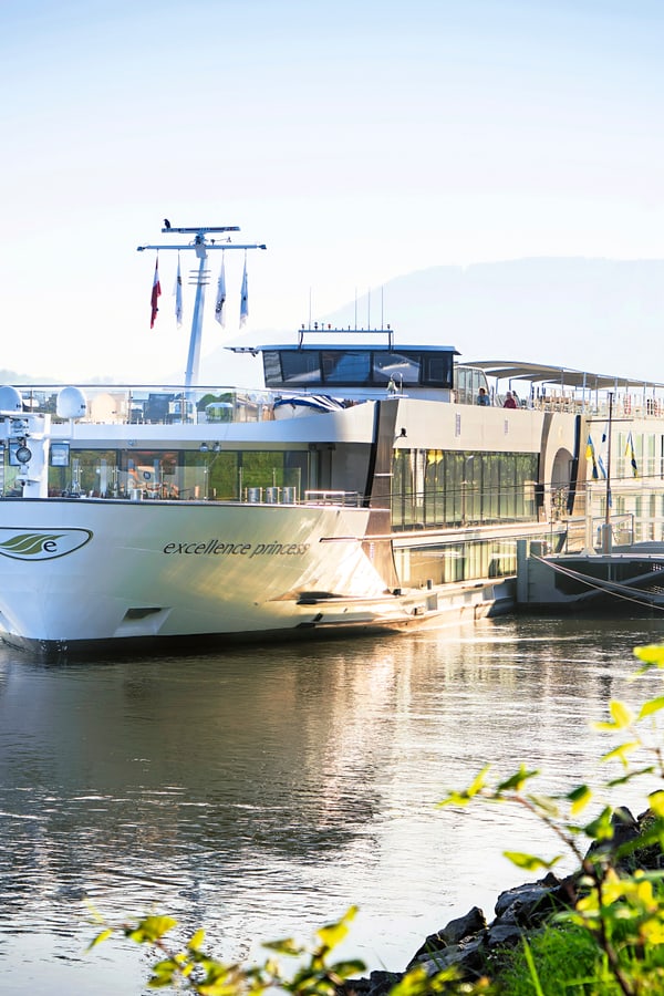 Flusskreuzfahrtschiff am Morgen auf einem ruhigen Fluss.