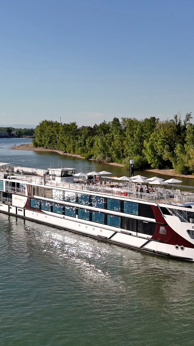 excellence-crown.jpg Flusskreuzfahrtschiff fährt auf einem Fluss, mit Bäumen am Ufer.