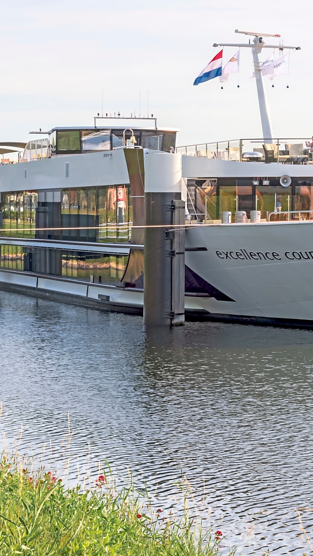 excellence-countess.jpg Ein grosses Schiff ist an einem Flussufer vertäut.