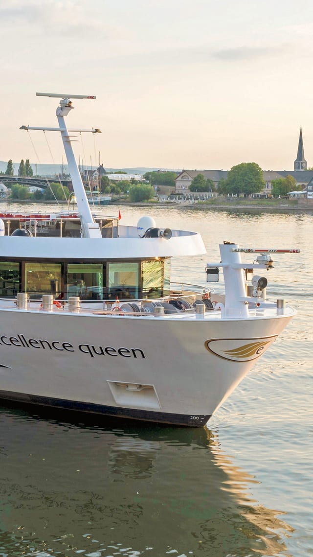excellence-queen.jpg Flusskreuzfahrtschiff auf dem Wasser bei Sonnenuntergang.