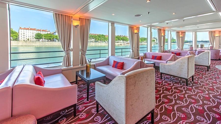Innenraum einer Lounge mit Sofas und Blick auf einen Fluss.