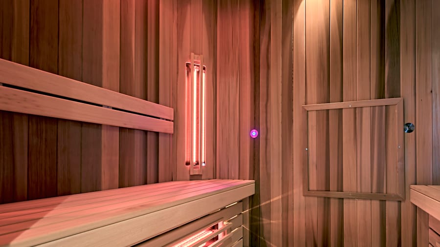 Innenraum einer modernen Sauna mit Holzverkleidung und Infrarotstrahler.