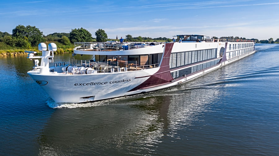 Flusskreuzfahrtschiff auf einem Fluss mit klarem Himmel.
