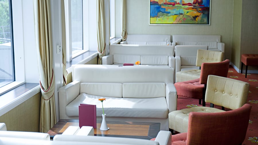 Heller Lounge-Bereich mit weissen Sofas und farbigem Gemälde.