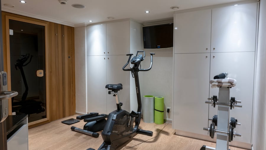 Fitnessraum mit Heimtrainer und Hanteln.