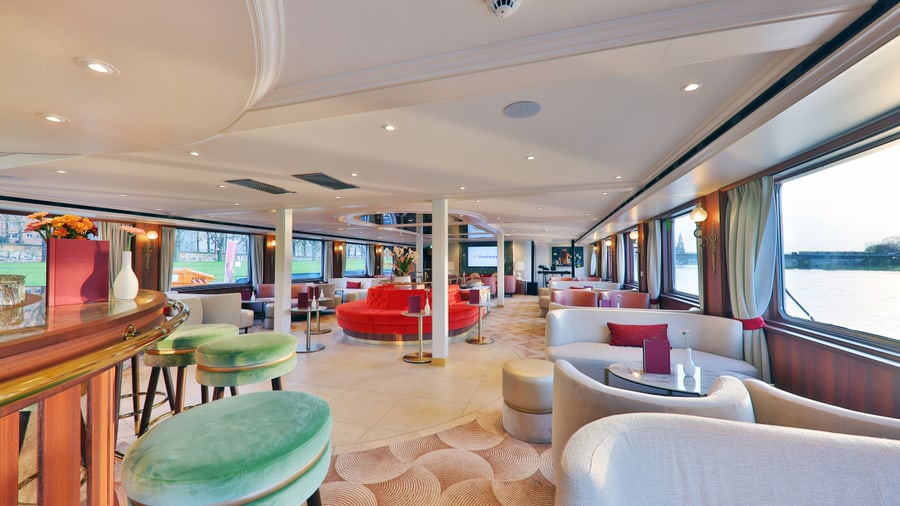 Eleganter Innenraum einer Schiffslounge mit Blick auf den Fluss.