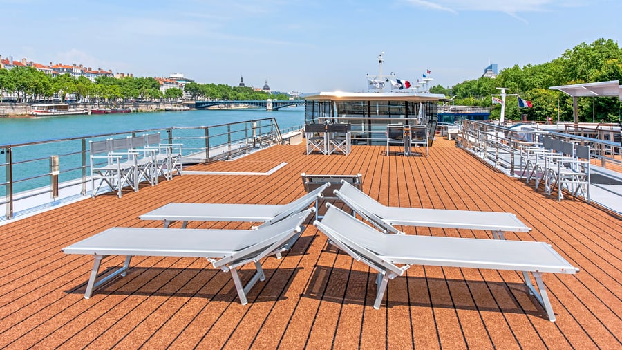 Liegestühle auf dem Deck eines Flussschiffs am sonnigen Tag.