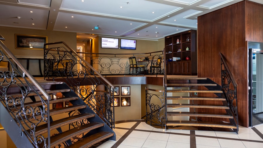 Innenraum mit eleganter Treppe und Monitoren an der Wand.