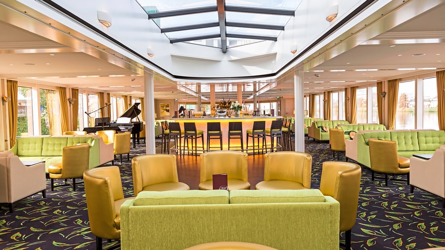 Eleganter Lounge-Bereich mit Bar, Klavier und Sesseln.