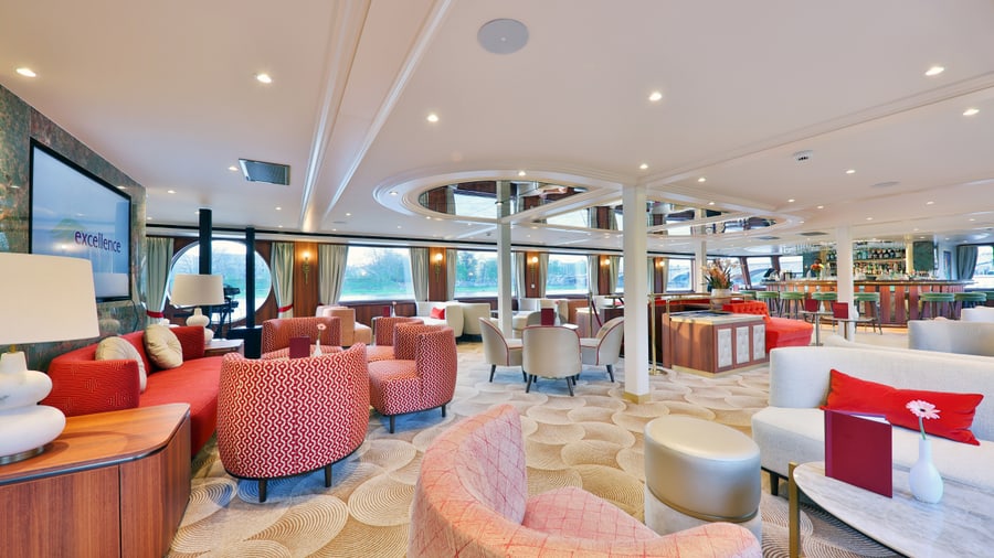 Eleganter Lounge-Bereich auf einem Schiff mit roten Sesseln.