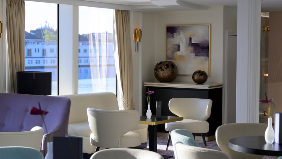 Eleganter Loungebereich mit Sesseln und grossen Fenstern.