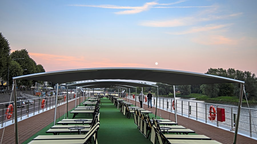 Sonnendeck eines Schiffes am Fluss bei Sonnenuntergang.