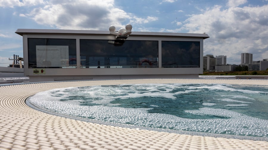 Whirlpool auf einem Kreuzfahrtschiff unter bewölktem Himmel.