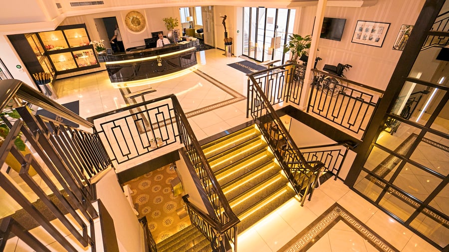 Elegante Hotel-Lobby mit Treppe und Rezeption.
