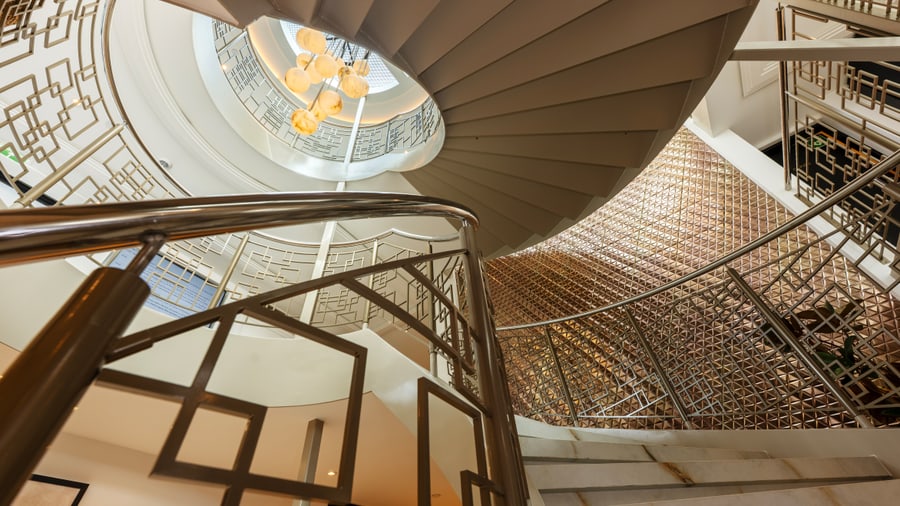 Innenansicht einer spiralförmigen Treppe mit elegantem Geländer.