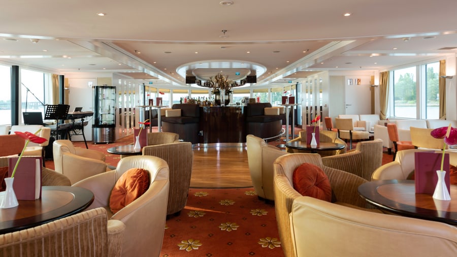 Eleganter Schiffs-Loungebereich mit Sesseln und Tischen.