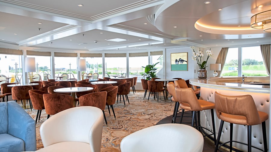 Elegante Lounge mit Tischen, Stühlen und Bar.