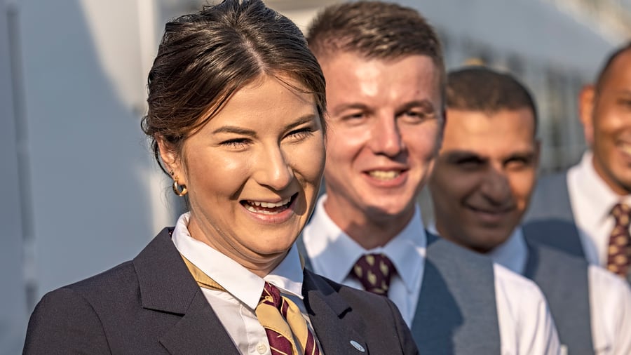Lächelnde Personen in Uniformen stehen in einer Reihe.