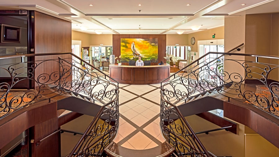 Elegante Hotellobby mit doppelt geschwungener Treppe.
