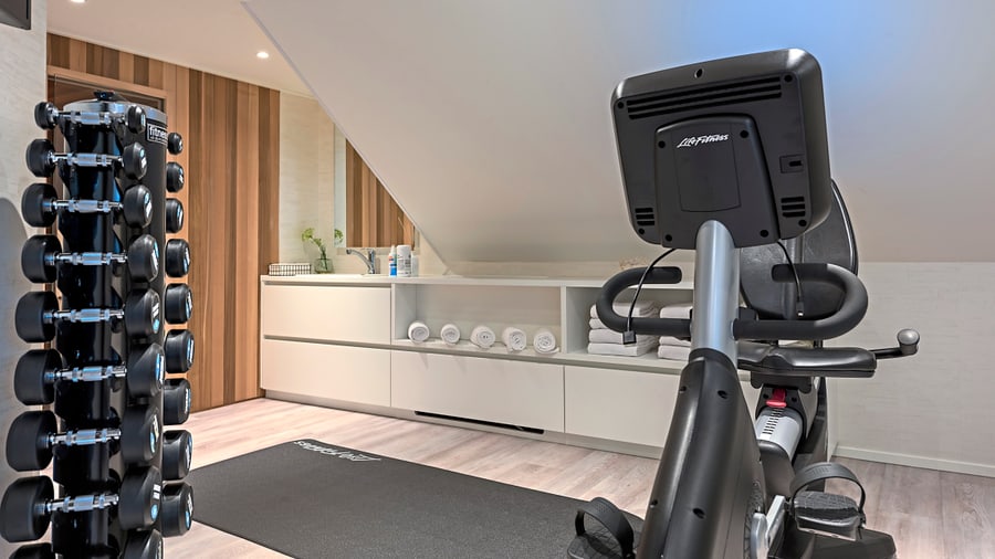 Heimgymnastikraum mit Ergometer und Hanteln.