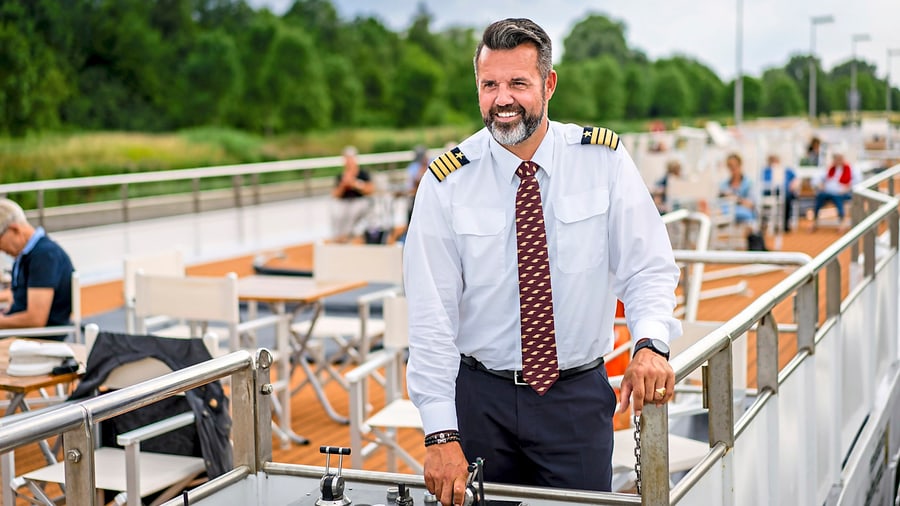 Kapitän steht an Bord eines Schiffes auf dem Deck.
