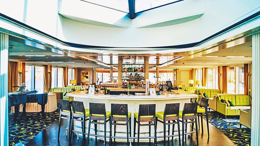 Moderne Hotelbar mit runder Theke und Barhockern.