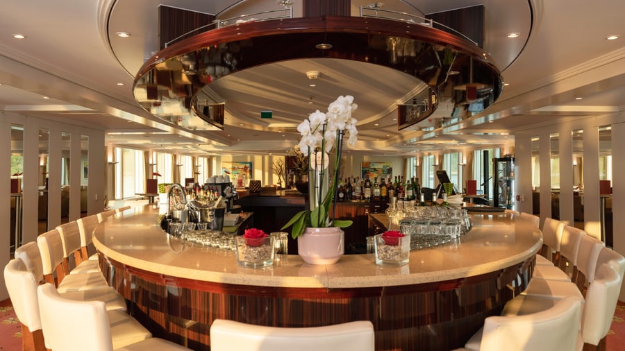 Elegante Schiffsbar mit runder Theke und Orchidee.