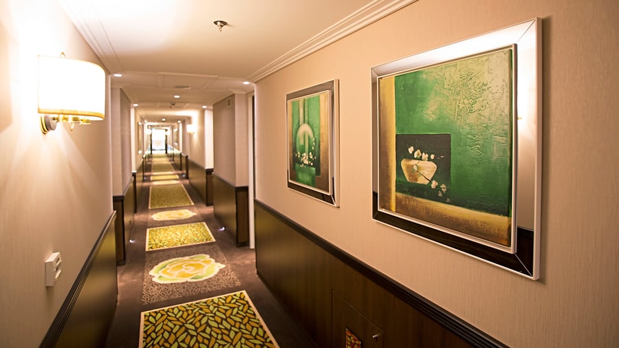 Moderner Hotelflur mit Bildern und Teppich.