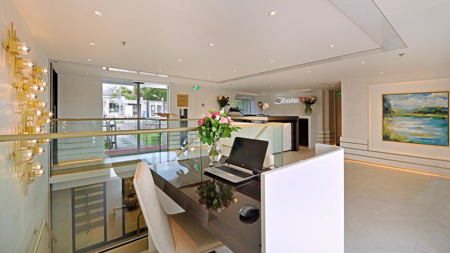 Helles, modernes Hotellobby-Interieur mit Rezeptionstresen und Laptop.