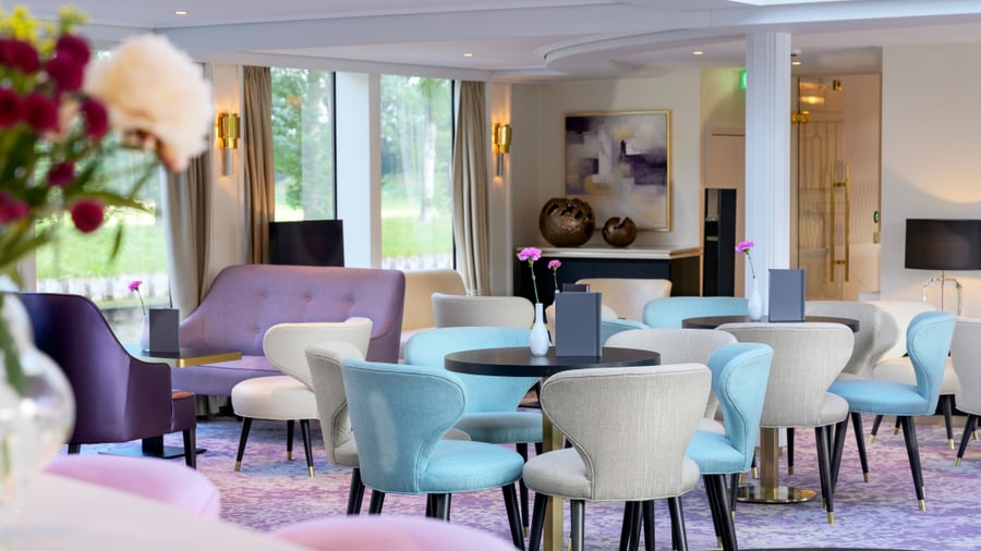 Helle, moderne Lounge mit bunten Sesseln und Tischen.