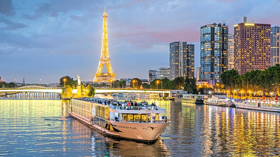 Beleuchtetes Schiff auf der Seine, Eiffelturm im Hintergrund.