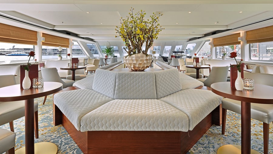 Eleganter Salon mit moderner Lounge und Blumengesteck.
