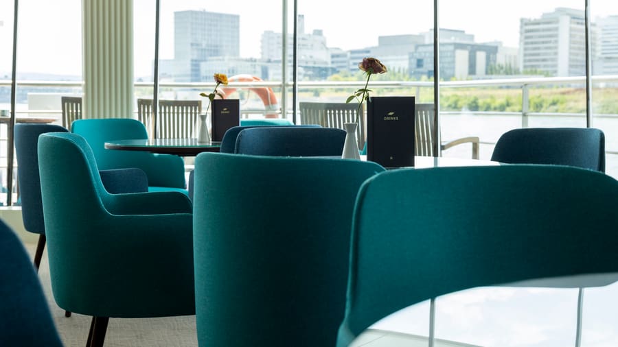 Moderne Lounge mit blauen Sesseln und Blumen.