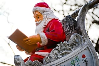 lichterglanz-am-main-7.jpg Weihnachtsmannfigur in Schlitten liest Buch.
