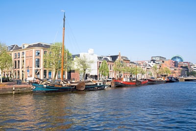 Boote am Kanal, umgeben von historischen Gebäuden bei klarem Himmel.