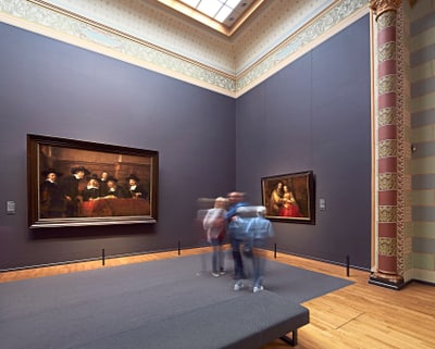 Menschen betrachten Gemälde in einem Museum.